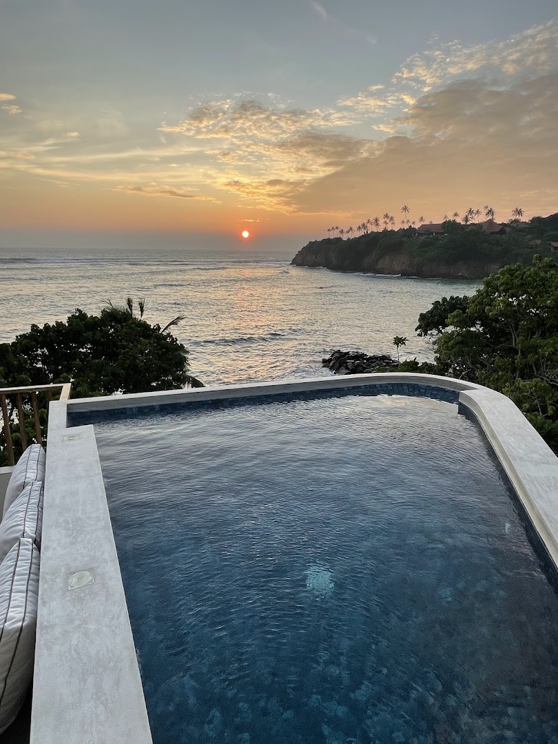 Sunset over the ocean and a private pool