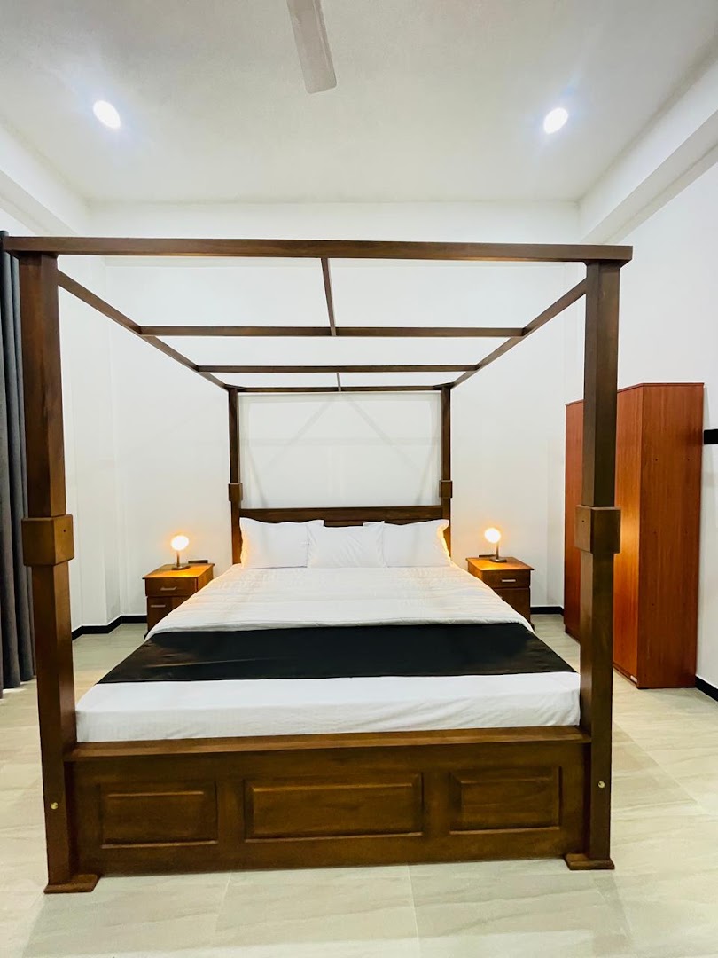 Four poster timber bed in a bright white room